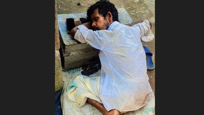 জুতা সেলাই করতে করতে যেন ক্লান্ত হয়ে ঘুমিয়ে পড়েছেন রতন কুমার দাস