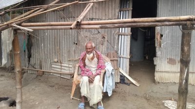 ঘরের সামনে ভাঙা প্লাস্টিকের চেয়ারে বসা মতিয়ার রহমান