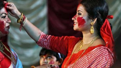 নারীরা আনন্দে একে অপরের মুখে সিঁদুর মাখেন