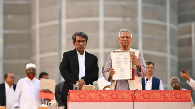 সইয়ের পর জুলাই জাতীয় সনদের কপি প্রদর্শন করছেন প্রধান উপদেষ্টা, ছবি: প্রধান উপদেষ্টার প্রেস উইং