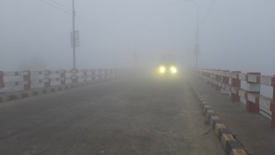 কুয়াশার সকালে হেডলাইট জ্বালিয়ে চলছে গাড়ি
