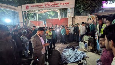 ককটেল বিস্ফোরণে নিহত যুবকের মরদেহ ঘিরে আইনশৃঙ্খলা বাহিনীর সদস্যরা (ছবি: ফয়সাল ইসলাম রাজীব)