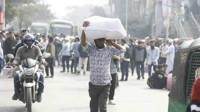 রাস্তা অবরোধ করায় বস্তা মাথায় নিয়ে হাঁটা শুরু করেছেন এক যাত্রী