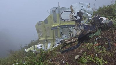 উদ্ধারকারীরা বুলুসারাং পর্বতের আশপাশে বিমানটির ধ্বংসাবশেষ উদ্ধার করেছেন। ছবি: ইপিএ