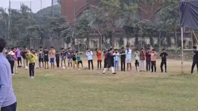 ঢাবির কেন্দ্রীয় মাঠে খেলতে আসা কিছু কিশোর কানেধরে উঠবস করছে। আর লাঠি হাতে নিয়ে তাদের শাসাচ্ছেন ডাকসুর কার্যনির্বাহী সদস্য সর্বমিত্র চাকমা। ছবি: সংগৃহীত