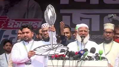 নাহিদ ইসলামের হাতে শাপলা কলি প্রতীক তুলে দিচ্ছেন জামায়াতের আমির ডা. শফিকুর রহমান। ছবি: বাংলা ট্রিবিউন
