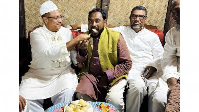একে অপরকে মিষ্টিমুখ করান নুরুল আমিন (বাঁয়ে) ও অ্যাডভোকেট সাইফুর রহমান