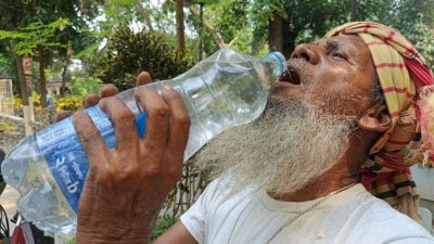 তীব্র গরমে পানি পান করছেন এক বৃদ্ধ শ্রমজীবী
