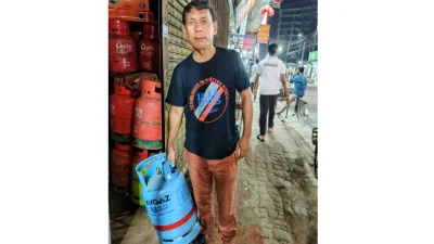 খালি সিলিন্ডার হাতে নিয়ে দোকানে দাঁড়িয়ে ক্রেতা