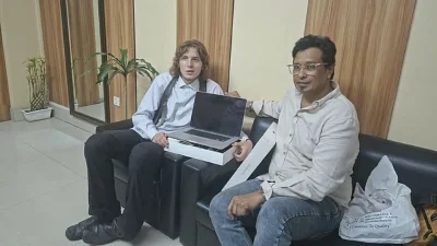 জার্মান পর্যটক ১৮ বছর বয়সী ক্রিল ল্যান্ডারে হাতে ম্যাকবুক তুলে দিচ্ছেন মুক্তি মাহমুদ (ছবি: মুক্তি মাহমুদের সৌজন্যে)