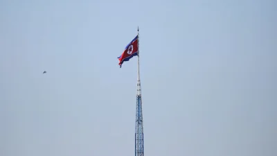একটি টাওয়ারের চূড়ায় উত্তর কোরিয়ার পতাকা উড়ছে। ছবি: রয়টার্স