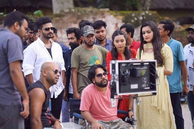 শুটিংয়ে মনিটরের সামনে বসা নির্মাতা এবং পাশে তিশা